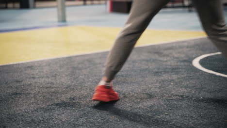 Nahaufnahme-Einer-Basketballspielerin,-Die-Nachts-Auf-Dem-Außenplatz-Trainiert-Und-Den-Ball-Hüpft-1