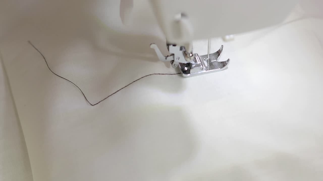 재봉틀을 사용하여 재봉된 천에 검은색 직선 재봉하기