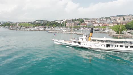 aerial of steam powered cruise ship sailing on lake geneva with the city of lausanne in the background