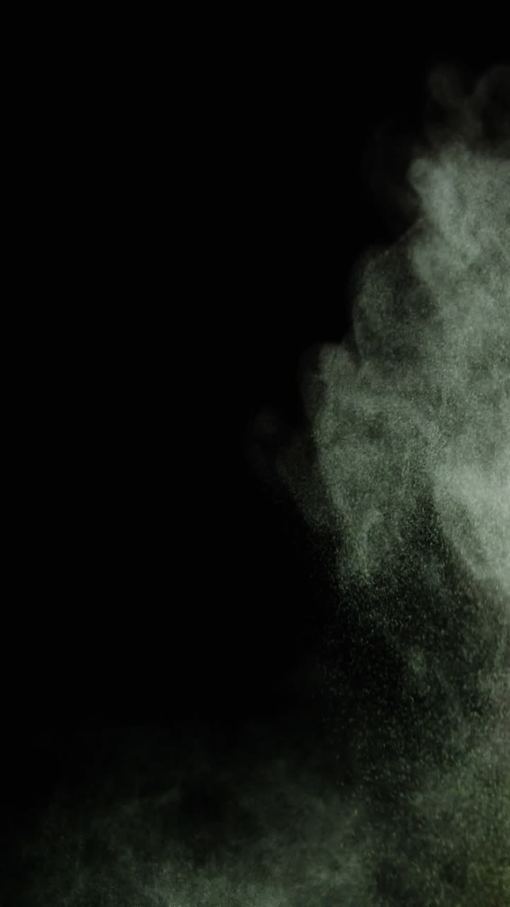 polvo verde y rojo soplando contra un fondo negro