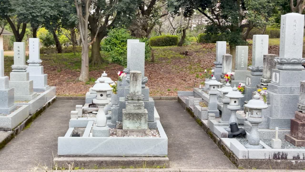 Una lenta panoramica su file di lapidi buddiste in pietra grigia a Kanazawa, Giappone.