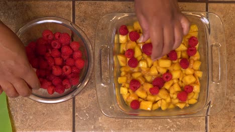 making a peach raspberry crisp - overhead view of hands at work