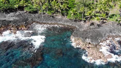 slow descent over volcanic coastline on hawaii island with waves and cliffs