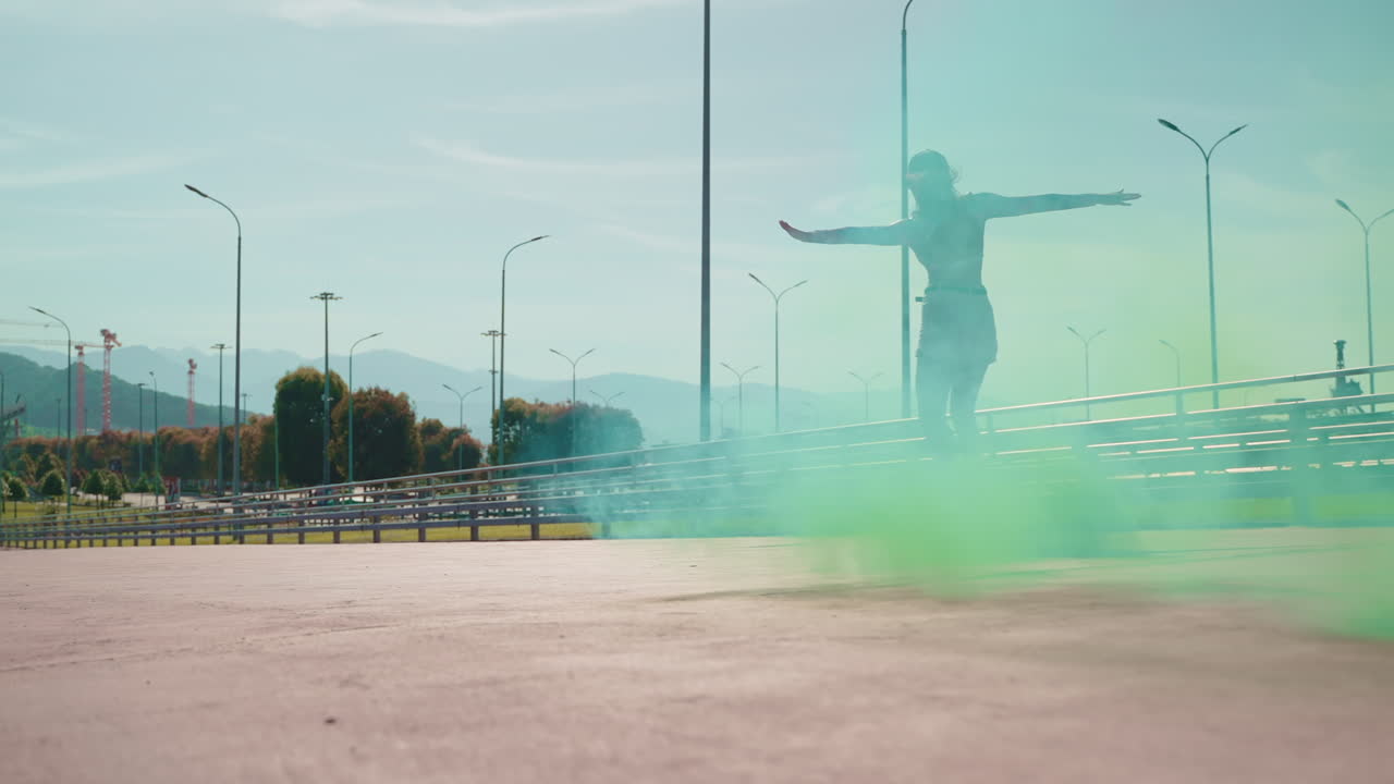 женщина катается на скейтборде в городе с зеленым дымом