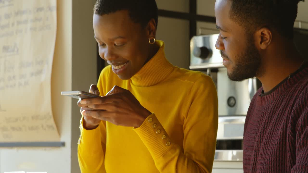 pareja usando teléfono móvil en el café 4k