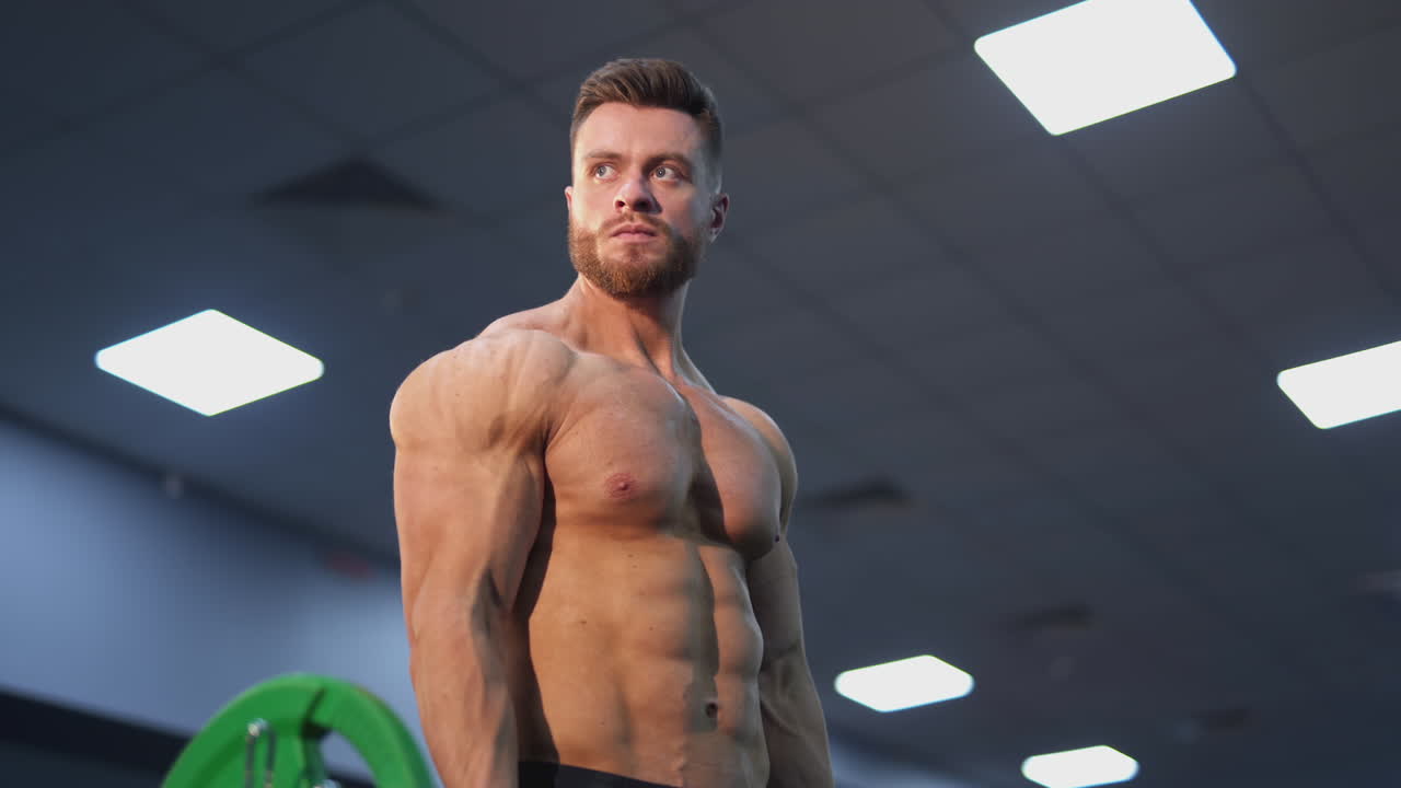 Bodybuilding man training his biceps. Young muscular man training hard at the gym.