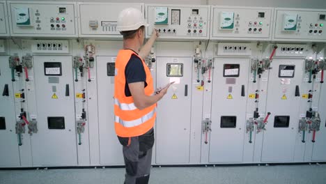 electrical engineer working check the electric current voltage and overload at front of load center cabinet or consumer unit for maintenance in main power distribution system room.