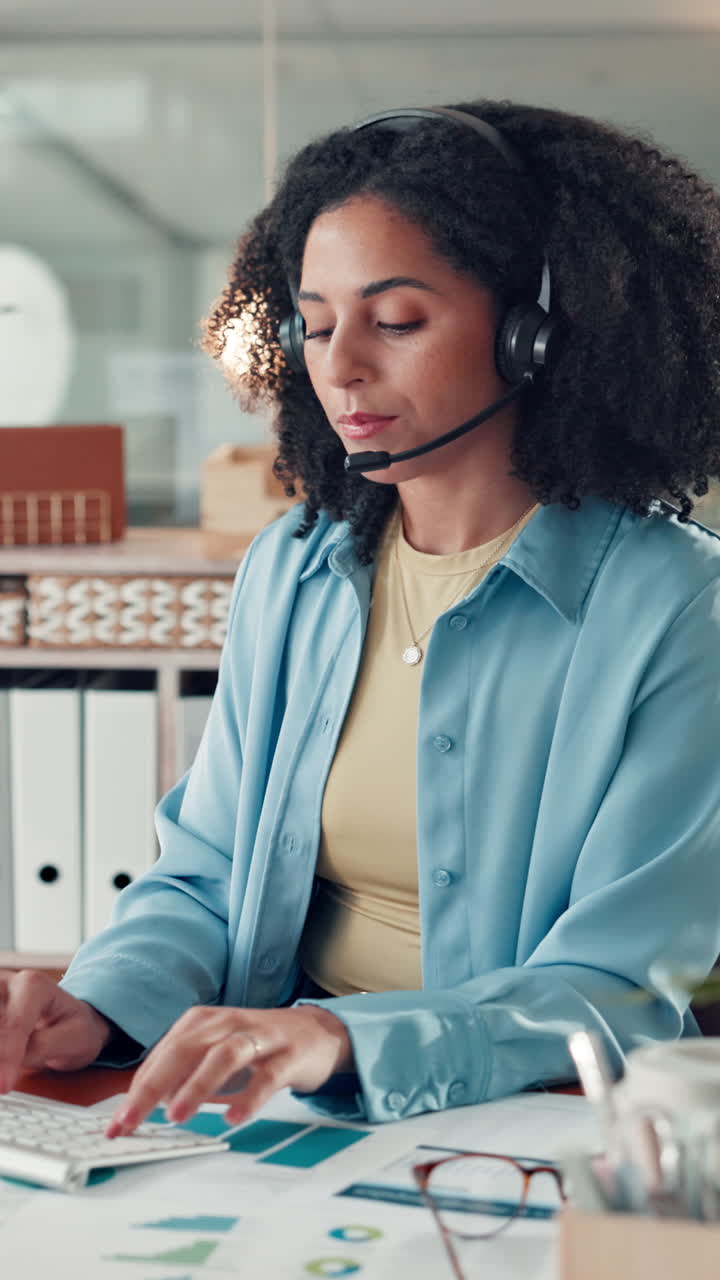 Profesjonell kvinne med headset som skriver på datamaskin på kontor