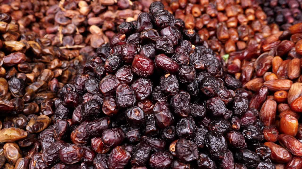 Variety of fresh Moroccan dates, shop display in the Medina of Marrakech (Marrakesh), Morocco. Healthy food snacks, high in vitamins and protein. 4k food background footage.