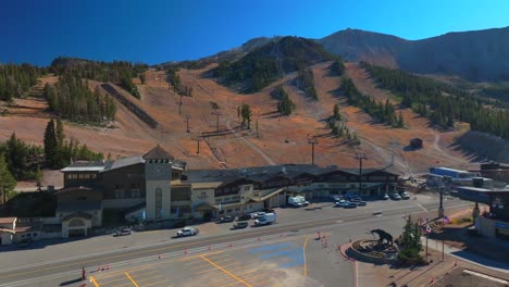 mammoth lakes mountain ski area aerial drone california mccoy station main lodge minarets upper panorama gondola summer autumn fall car parking lot sunny blue sky chairlift gondola static shot