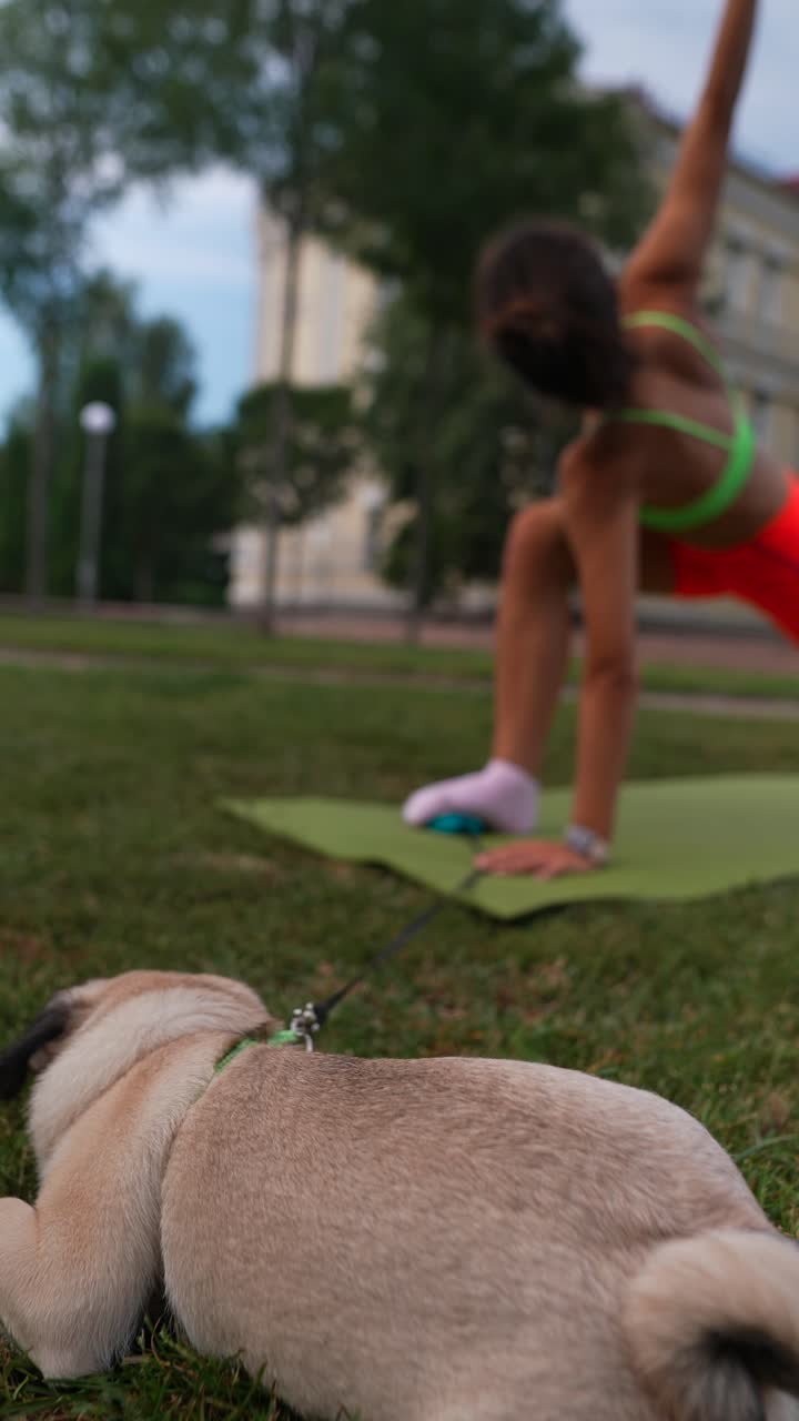 mujer haciendo yoga en el parque con el perro