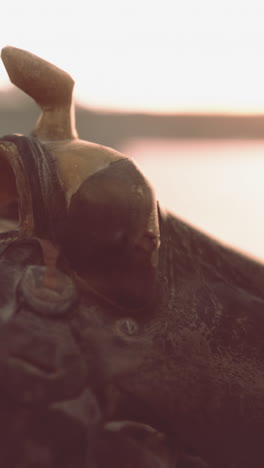 close up of an old leather saddle with sunset in the background