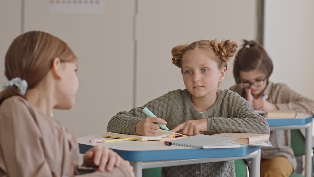 Schoolgirls Chatting during Lesson