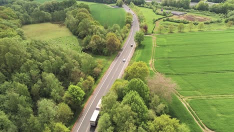 Vista-Aérea-De-Drones-De-La-Carretera-Rural-Alemana-Y-El-Tráfico-Entre-Campos-Verdes-En-El-Día-De-Verano