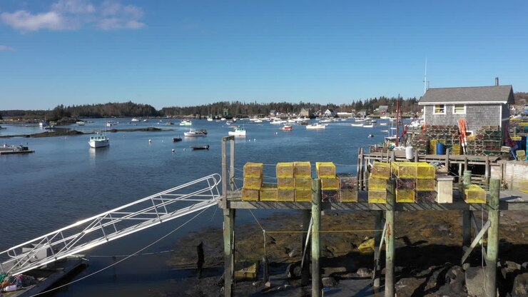 Riprese aeree veloci con drone che mostrano nasse per aragoste lungo la rampa di una peschiera di aragoste, vicino alle acque della costa del Maine a Vinalhaven, Isole Fox, Contea di Knox, Maine, USA
