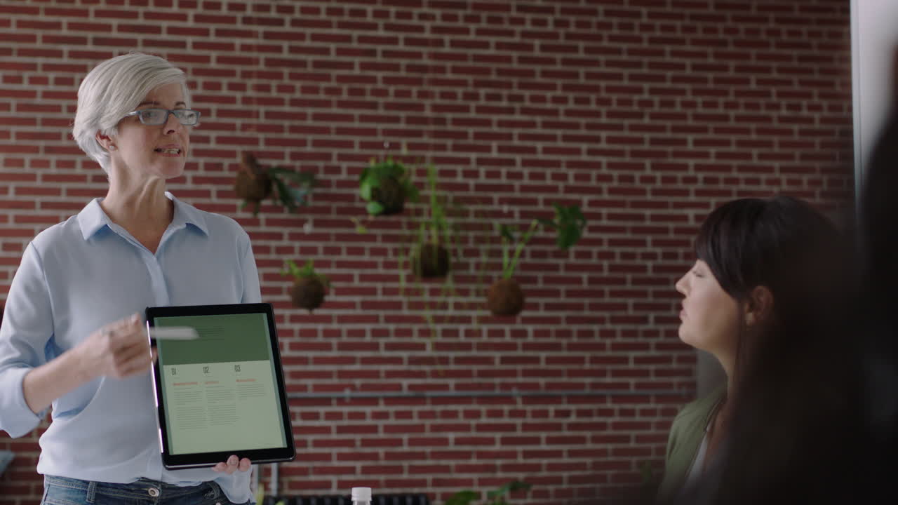 empresarios que se reúnen para hacer una lluvia de ideas gerente de equipo mujer que presenta ideas de marketing para un proyecto de inicio usando una tableta discutiendo la estrategia colegas que trabajan juntos en la oficina presentación