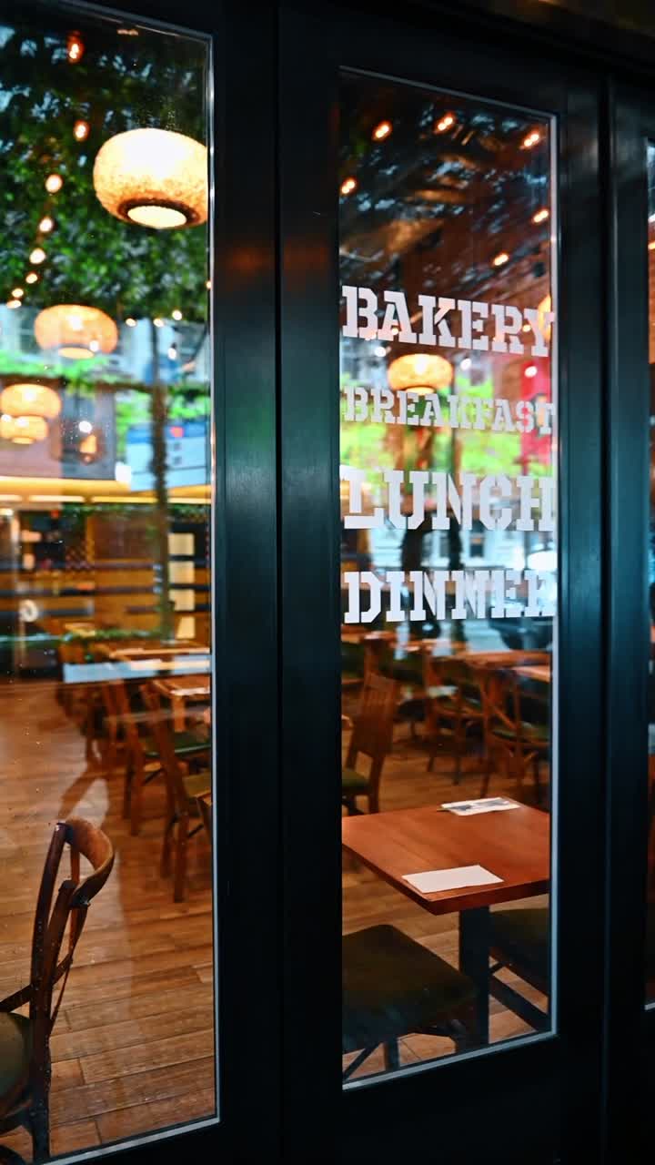New York, USA, 2. august 2025: Nærbillede af cafévindue med teksten 'morgenmad frokost middag'. Glasdør til en restaurant og middag med interiørreflektioner og lys.
