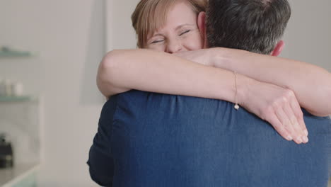 happy couple hugging excited woman embracing boyfriend sharing good news enjoying romantic relationship at home