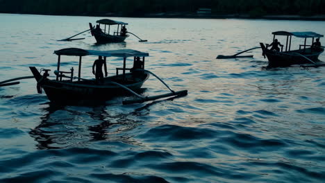 sunset over the water with longtail boats and people