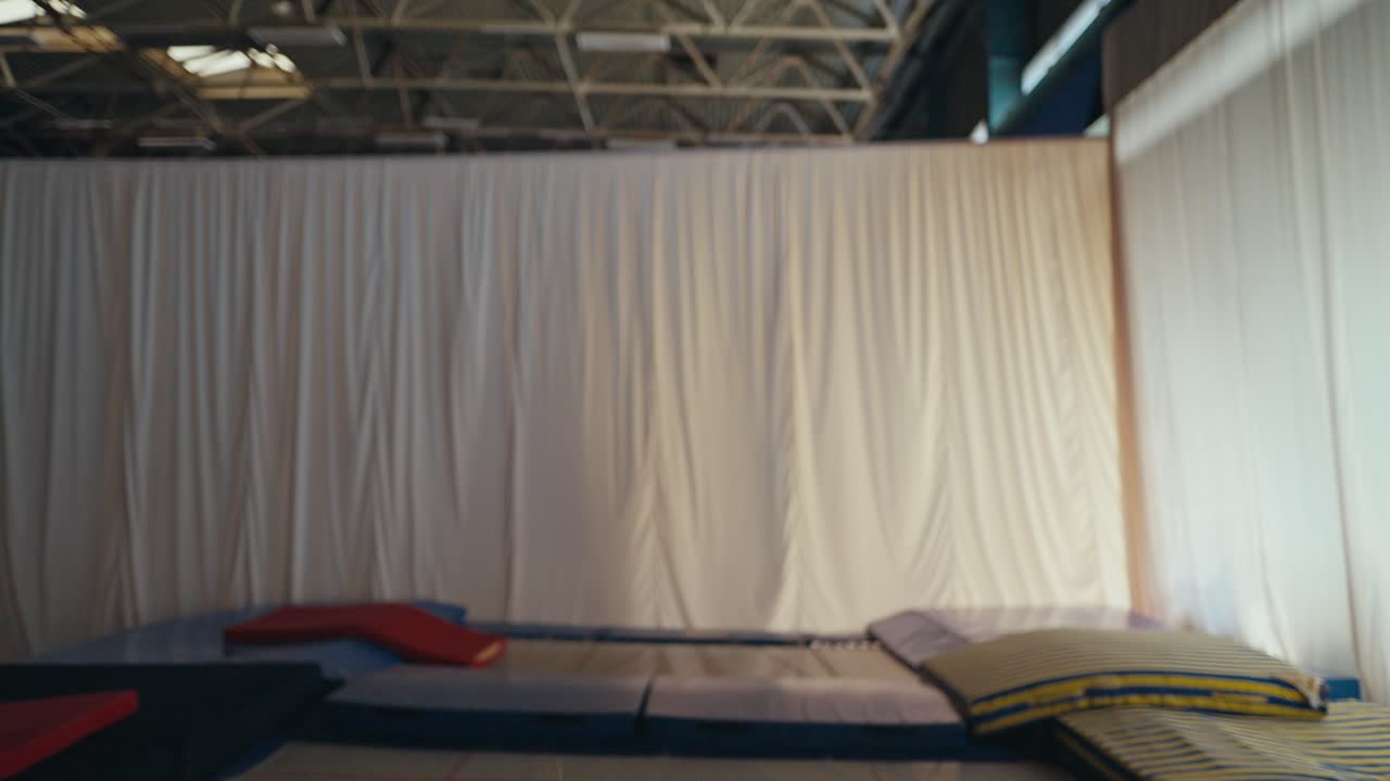 작은 소녀가 트램폴린에 뛰어다니며 행복하게 웃고 있습니다.