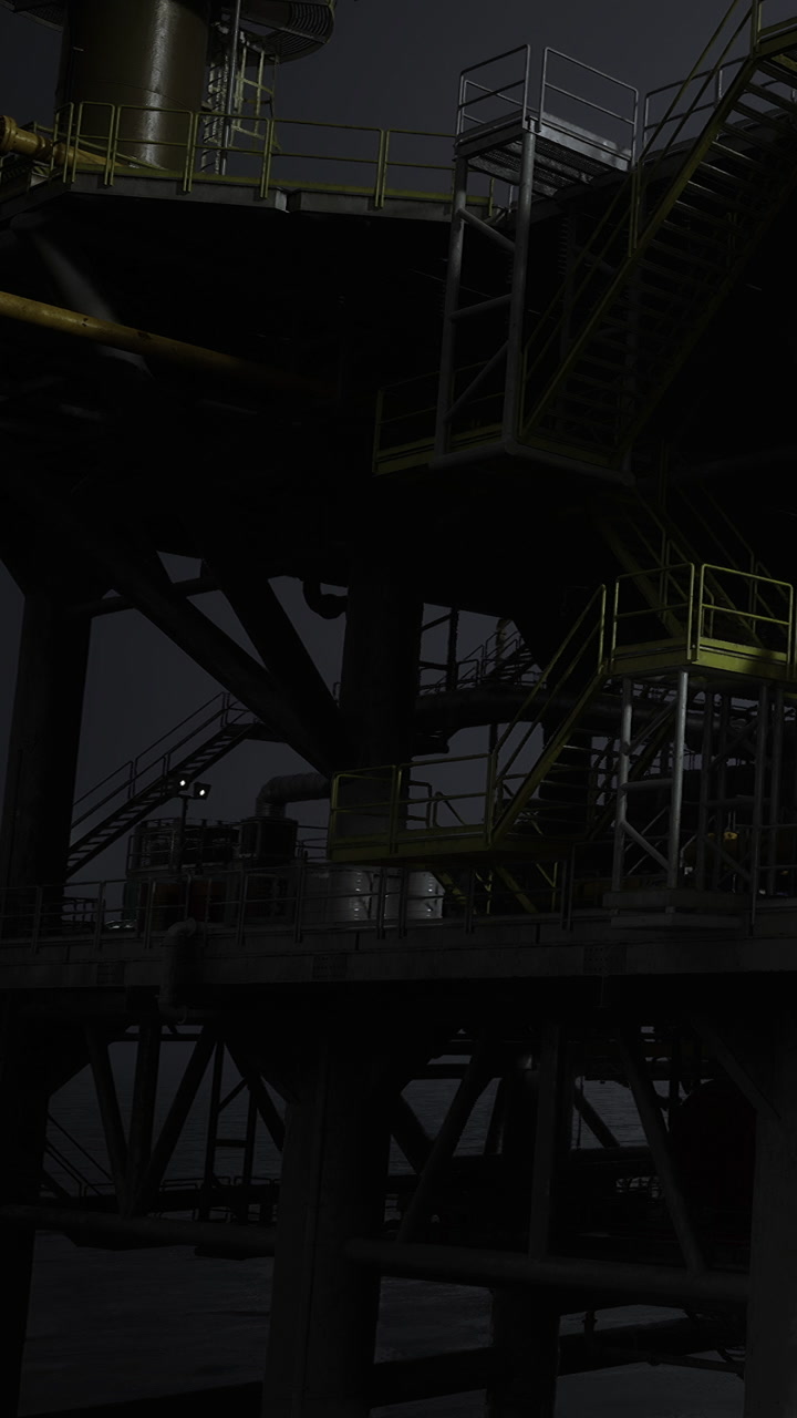 Oil rig platform at night with lights and structures visible in the dark