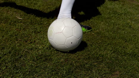 football player kicking the ball on grass