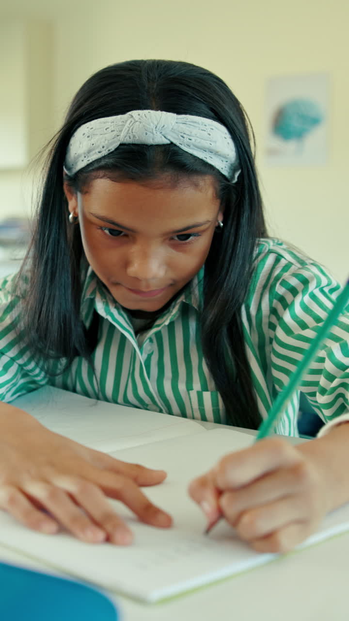 Giovane studente concentrato che scrive su un quaderno in classe