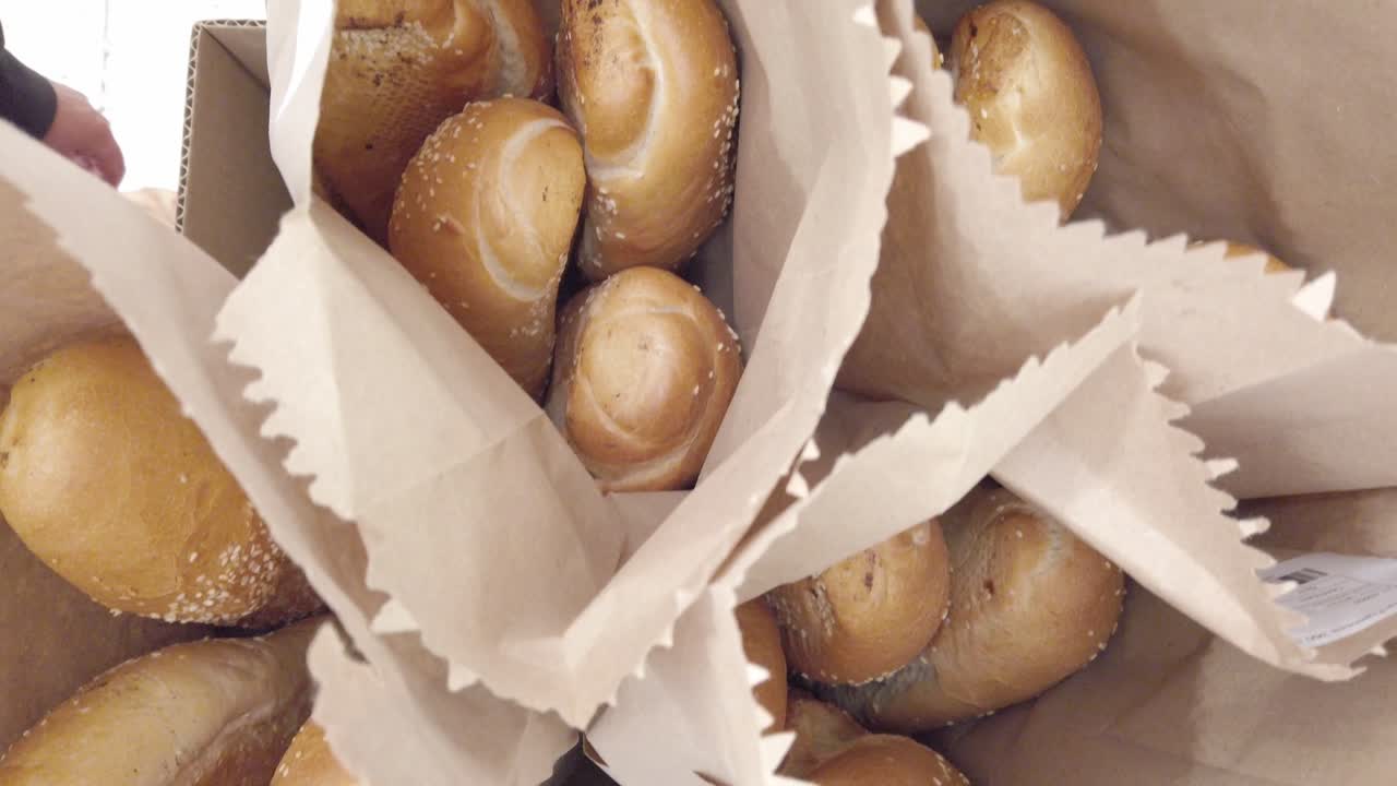 Freshly baked bread loaves packed in paper bags, close up food detail with natural light