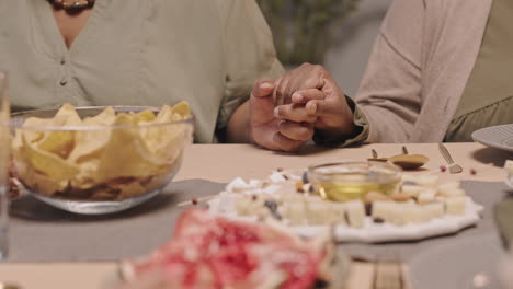 couple holding hands at dinner table