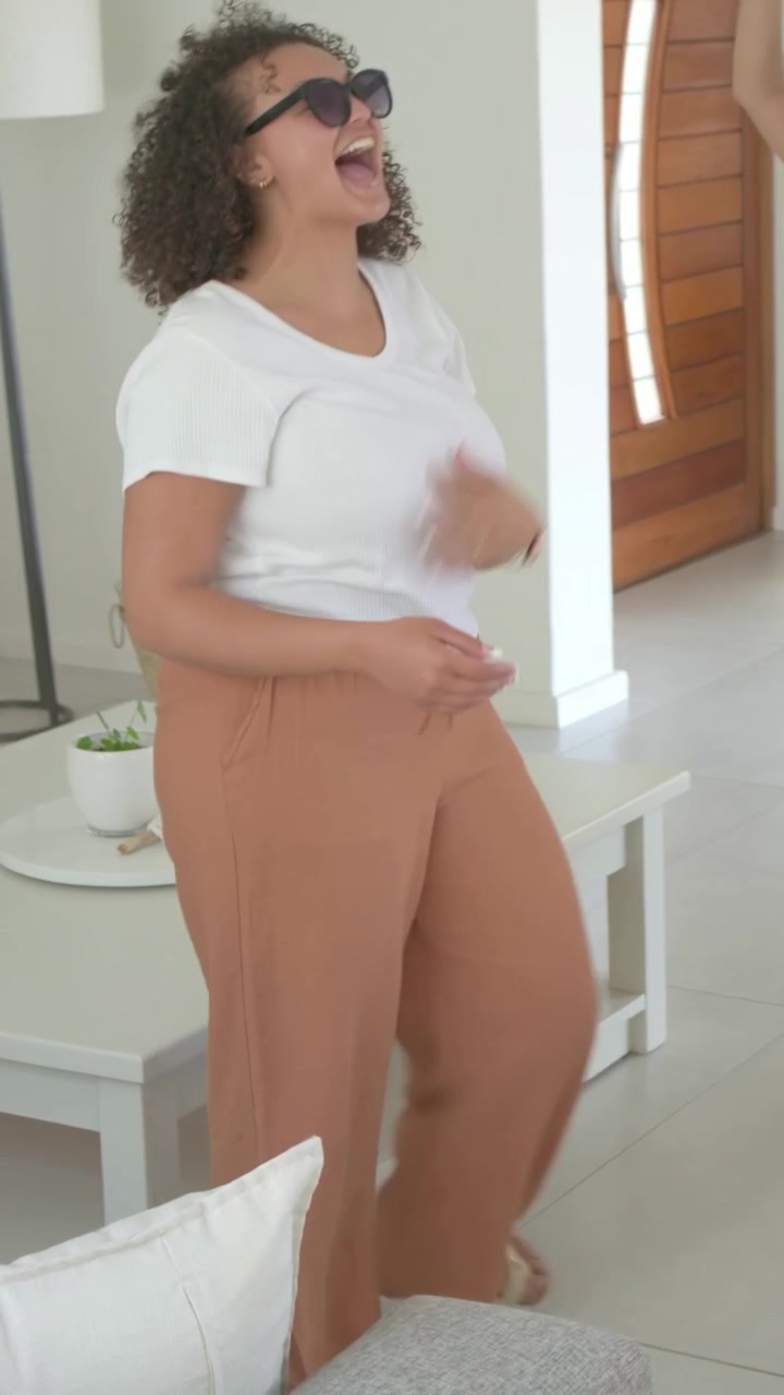 Video verticale: Due donne entrano nella stanza e ballano vicino a un tavolo, aggiustando gli occhiali da sole per lo stile di vita.