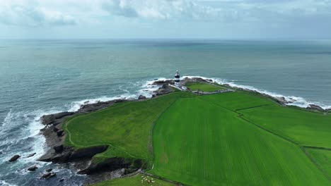 Irlands-Epische-Orte:-Die-Raue-Schönheit-Und-Abgeschiedenheit-Des-Hook-Head-Leuchtturms-Mit-Blick-Auf-Das-Meer-Und-Das-üppige-Grüne-Ackerland-Von-Wexford