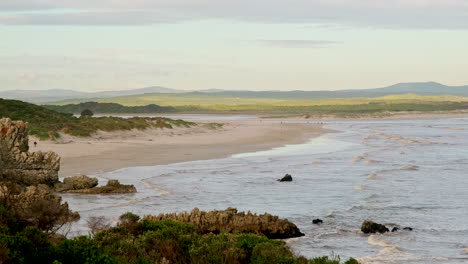 relaxing golden hour view down grotto blue flag beach with lapping waves