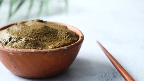 The-wooden-bowl-with-rehydrated-henna-on-table