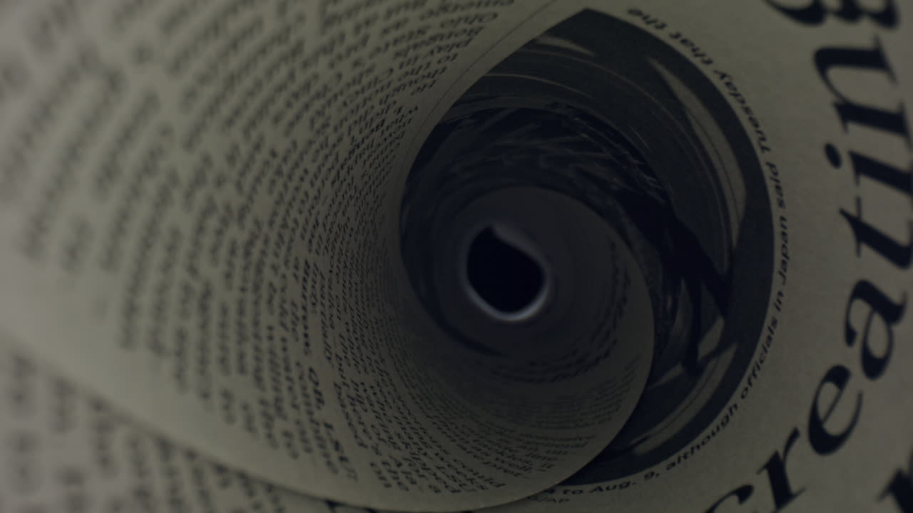 periódico enrollado con titulares de noticias