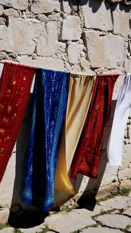 colorful clothes drying on a stone wall