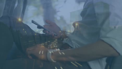 Animation-of-cars-on-street-over-caucasian-man-using-smartphone