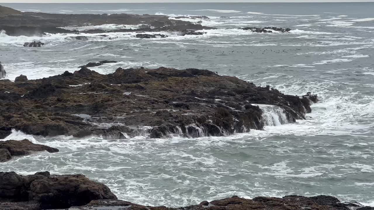 olas rompiendo en las rocas volcánicas. cámara lenta