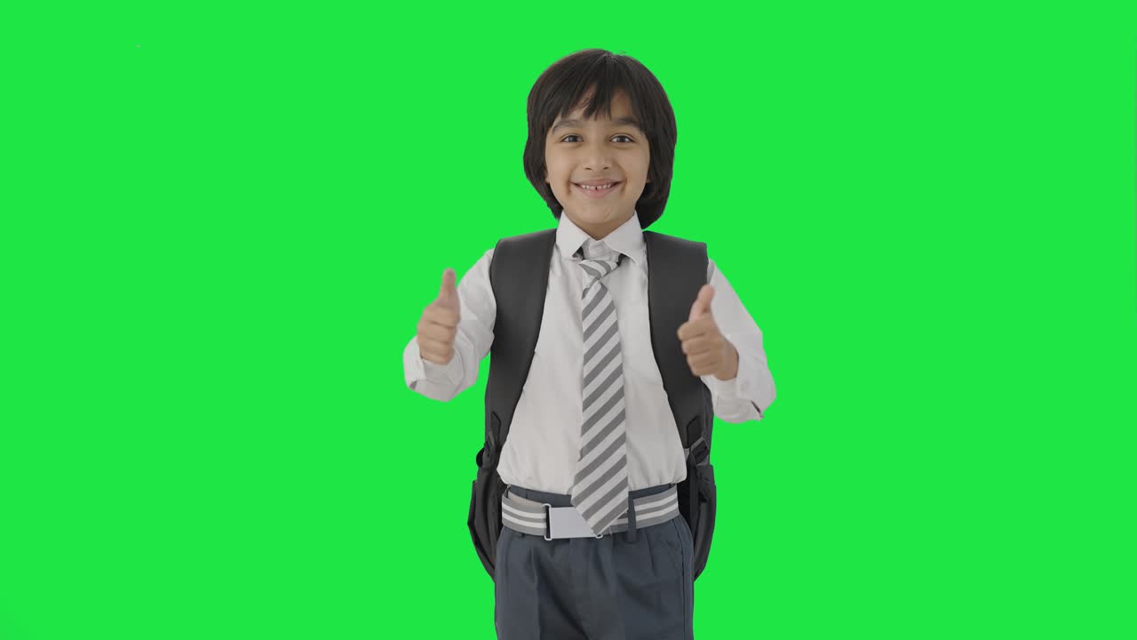 niño de escuela indio feliz mostrando los pulgares hacia arriba pantalla verde