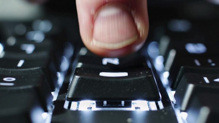 Approaching human fingertip pressing center key at desk, activating switch and revealing LED