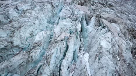 vista aérea de un glaciar de montaña con muchos craks derritiéndose en los alpes suizos