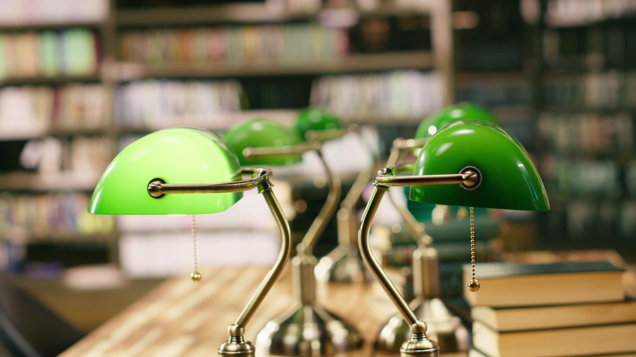 Close up view of stack of books near green lamps on wooden library table