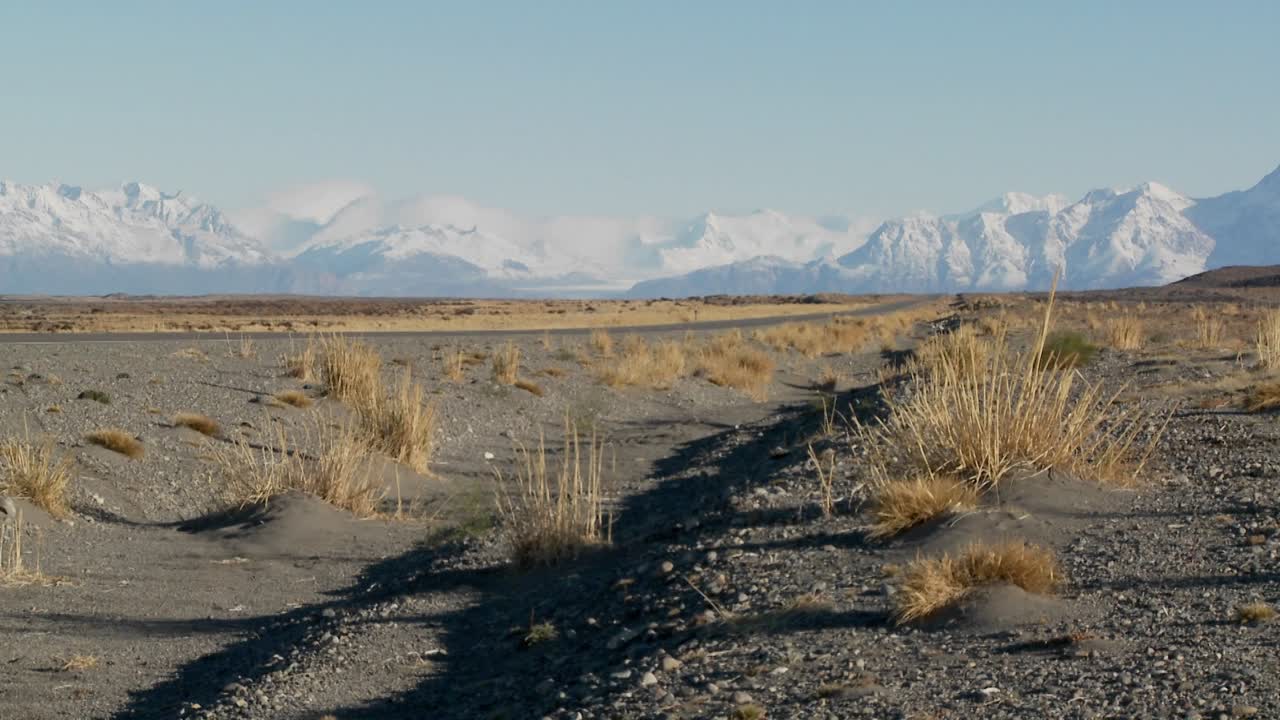 Un'auto su una strada isolata diretta verso le Ande in Patagonia, Argentina 1