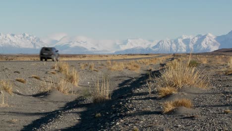 a car on a remote road heading into the andes mountains in patagonia argentina 1