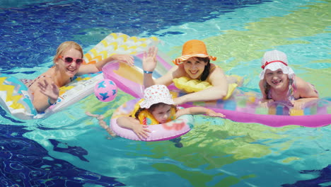 Glückliche-Eltern-Mit-Kindern-Schwimmen-Im-Pool-Halte-Dich-An-Einer-Luftmatratze-Fest-Blick-In-Die-Kamera-4