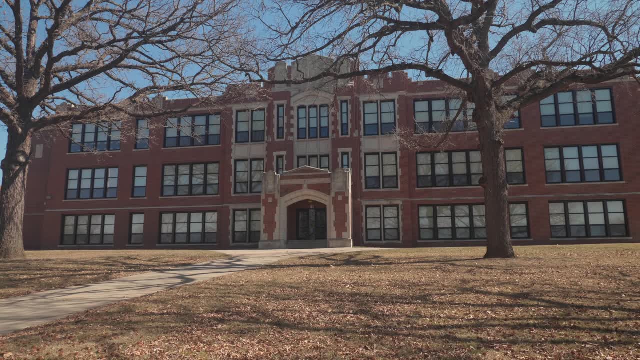 High School in Small American City, Building Exterior, View Behind Tree. Falls City, Nebraska USA