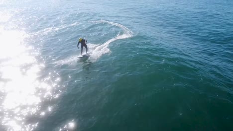 young surfer catching and riding a good wave on a sunny day with blue water.