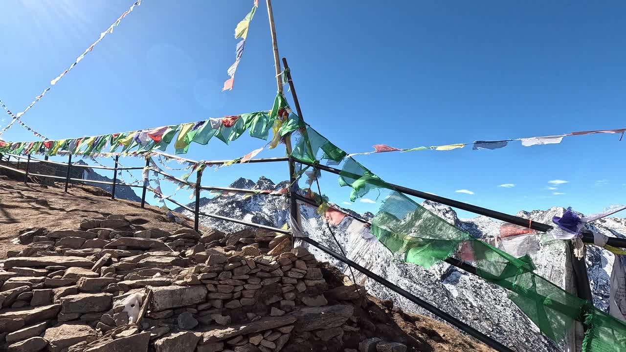 Looking over a beautiful snowy mountain chain with fresh snow. Revealing behind prayer flags on a railing. High altitudes in . Laurebina Mountain pass on Gosaikunda Trek