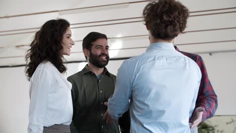 colegas sorridentes a apertar as mãos e a falar