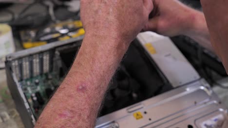 técnico anciano repara computadora rota con destornillador