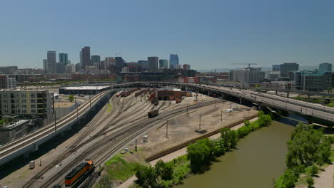 Downtown-Denver-Coors-field-Colorado-Rockies-baseball-stadium-Rocky-Mountain-landscape-South-Platte-River-aerial-drone-cinematic-foothills-Colorado-cars-traffic-Amtrak-train-spring-summer-up-movement